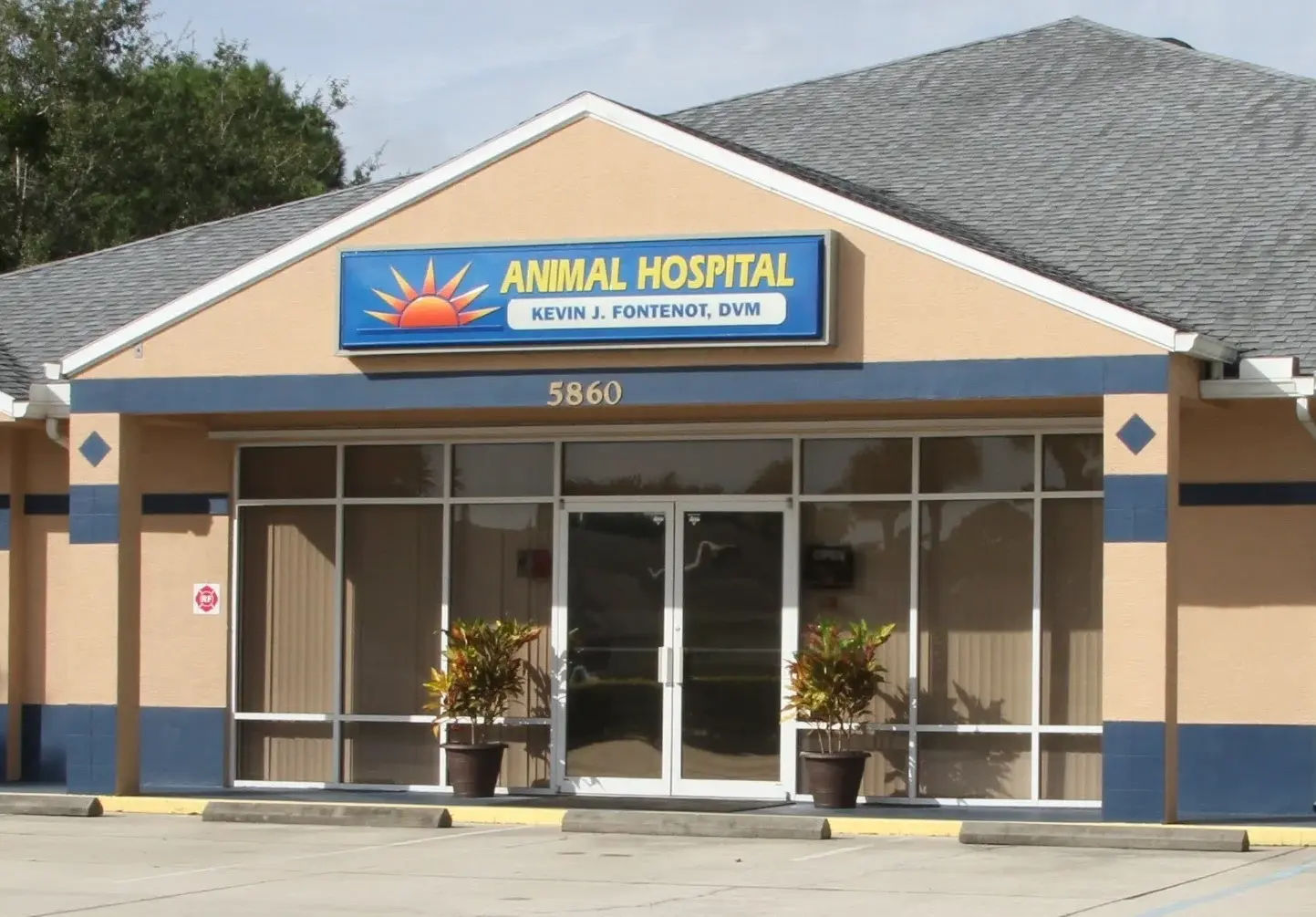 A large building with windows and plants outside it.