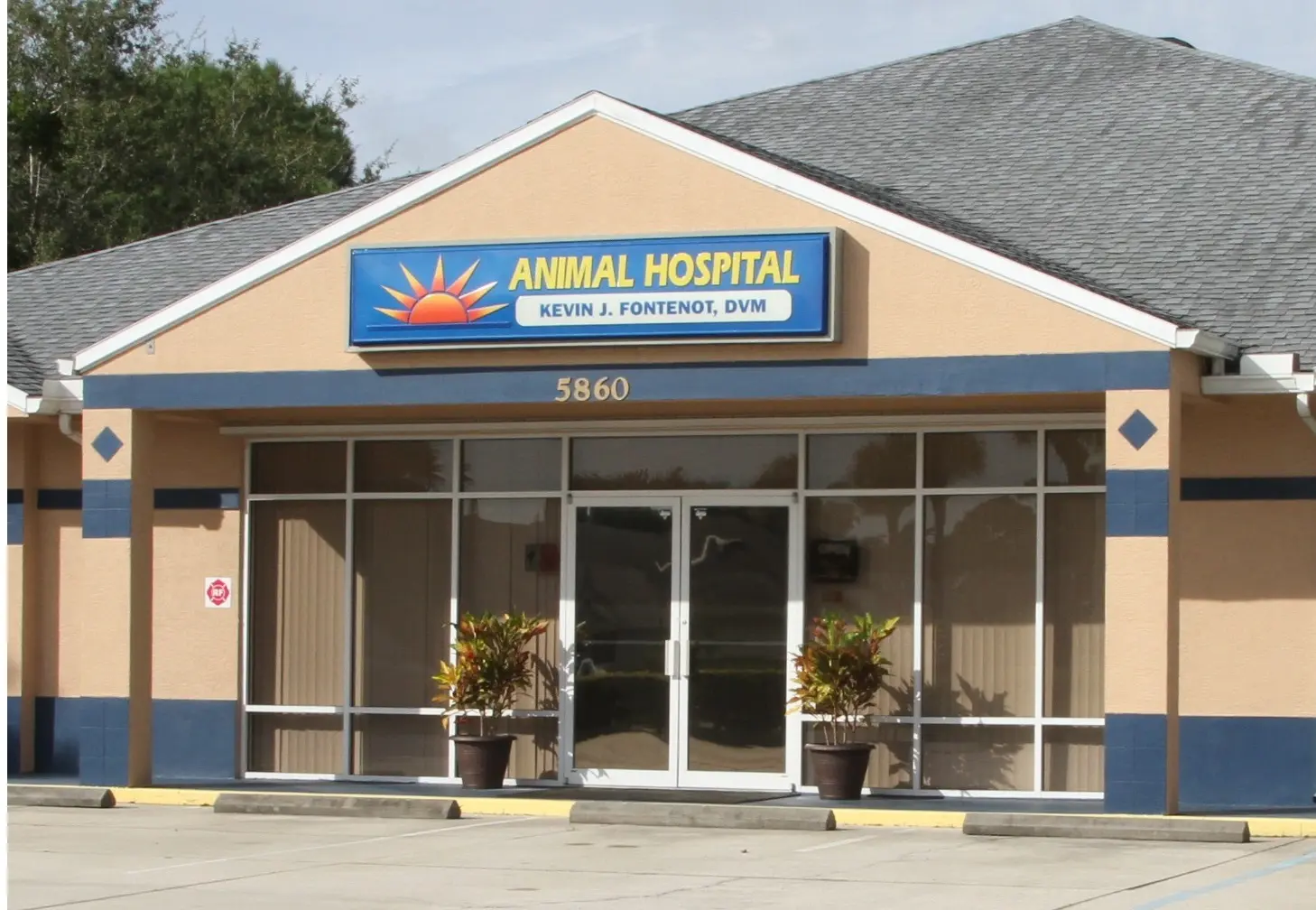 A large building with windows and plants outside it.