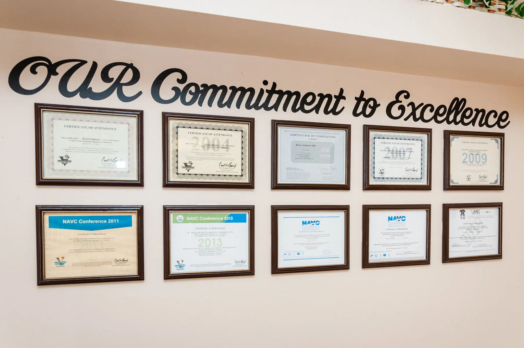 A wall with many certificates hanging on it